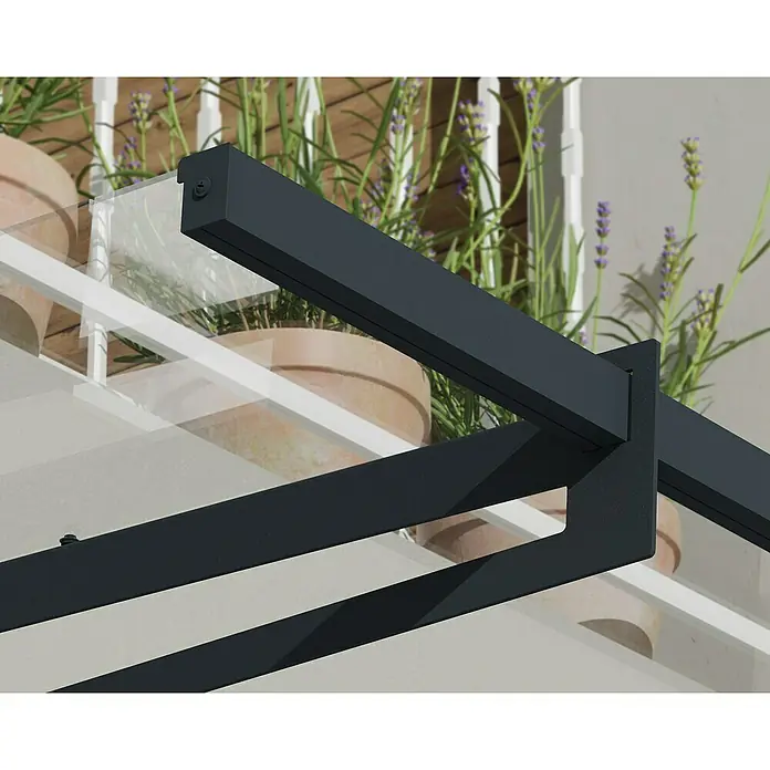 Palram – Canopia Pultvordach Bremen - 150 x 93,5 x 18,7 cm, Anthrazitgrau - Nahaufnahme einer modernen Terrassenüberdachung mit dunklem Rahmen und Glasscheiben, umgeben von Pflanzen.