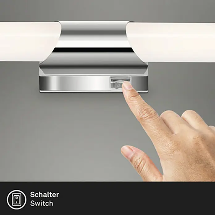 Briloner Aplique LED para espejo Klak - L x An x Al: 6,8 x 6,5 x 47 cm, Blanco/plateado, Blanco neutro - Una mano acciona el interruptor de una lámpara cromada, destacando el diseño y la funcionalidad de la iluminación del baño.