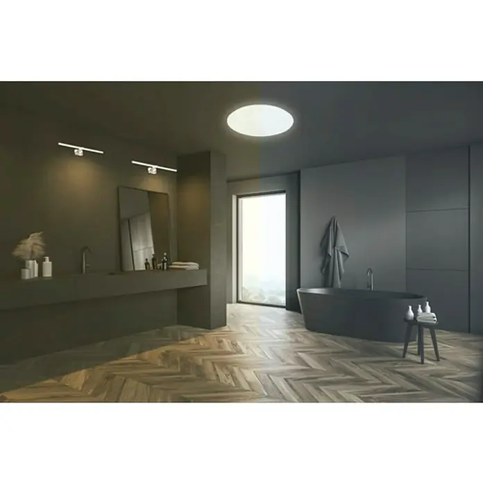 Briloner Plafón LED redondo Stelo - Ø x Al: 28 x 9,5 cm, Blanco estrellado, Color de luz: Blanco neutro - Un baño oscuro con bañera exenta, tocador con espejo y lámpara de techo, creando un ambiente moderno y elegante.