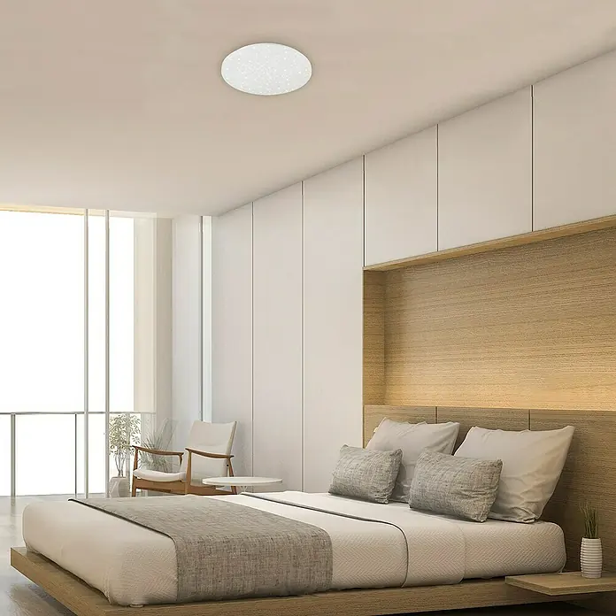 Briloner Plafón LED redondo Brili - Ø x Al: 38,5 x 7,5 cm, Blanco, Blanco neutro - Un dormitorio moderno con una lámpara de techo redonda y blanca que difunde una luz suave y crea un ambiente tranquilo en la habitación.