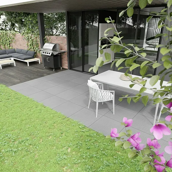 Terrassenfliese Slate Grey60 x 60 x 2 cm, Grau, Matt - Ein stilvoller Außenbereich mit Grill, Esstisch und bequemer Lounge lädt zum Verweilen ein. Moderne Gartengestaltung mit grauen Fliesen und Grünflächen.