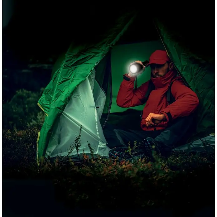Energizer Linterna Tactical Ultra - 200 lm - 1.000 lm, IPX7 - Un hombre sentado en una tienda ilumina el interior con una linterna. Equipo de camping ideal para aventuras al aire libre.