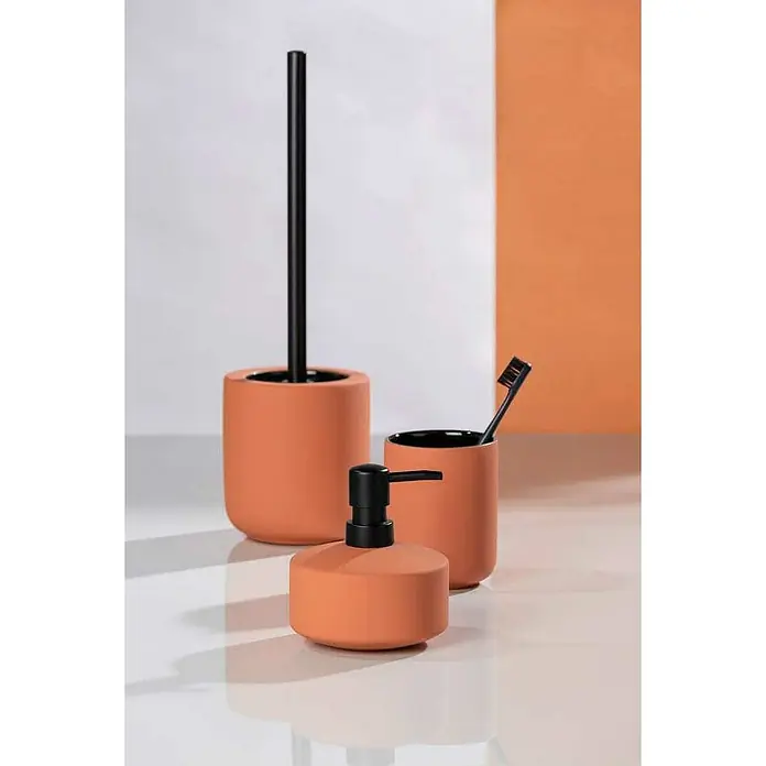 Wenko Seifenspender Avellino - Keramik, Terracotta - Nahaufnahme eines orangefarbenen Badezimmersets mit Seifenspender, Zahnputzbecher und Toilettenbürste.