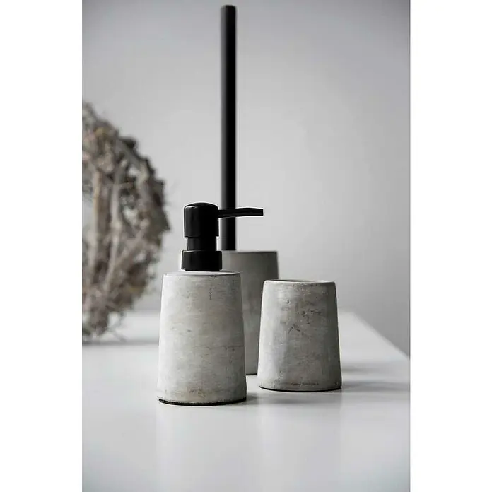 Wenko Seifenspender VillenaBeton, Grau - Ein graues Badezimmer-Set aus Seifenspender, Becher und Toilettenpapierhalter aus Beton, minimalistisch und modern gestaltet.