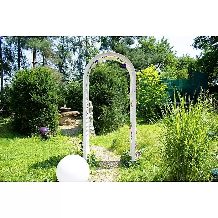 KHW Rosenbogen - Weiß, 100 x 43 x 207 cm - Weißer Gartenbogen mit lila Blumen über einem Weg in einem üppigen Garten. Eine weiße Kugelleuchte ist sichtbar.