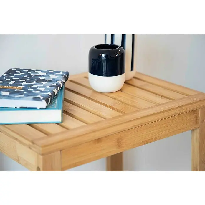 Wenko Bambusa Badhocker - B x H: 40 x 30 cm, Bambus - Nahaufnahme eines Holztisches mit Büchern und dekorativen Vasen, ideal für ein stilvolles und aufgeräumtes Ambiente.