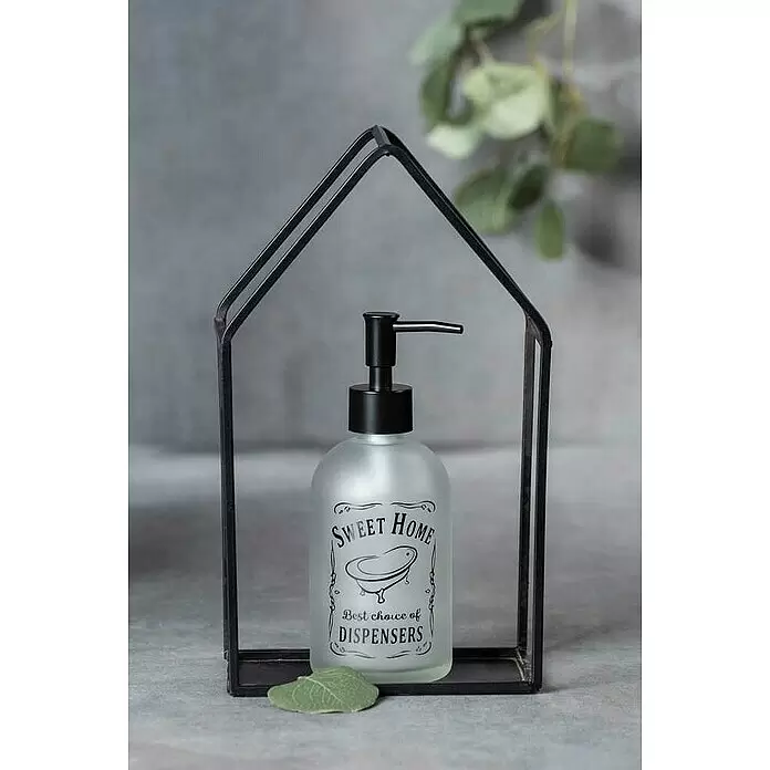 Wenko Seifenspender Sweet Home - Glas, Transparent - Seifenspender aus mattiertem Glas mit schwarzem Pumpkopf und "Sweet Home"-Schriftzug, in einem schwarzen, hausförmigen Metallrahmen, mit einem kleinen grünen Blatt.