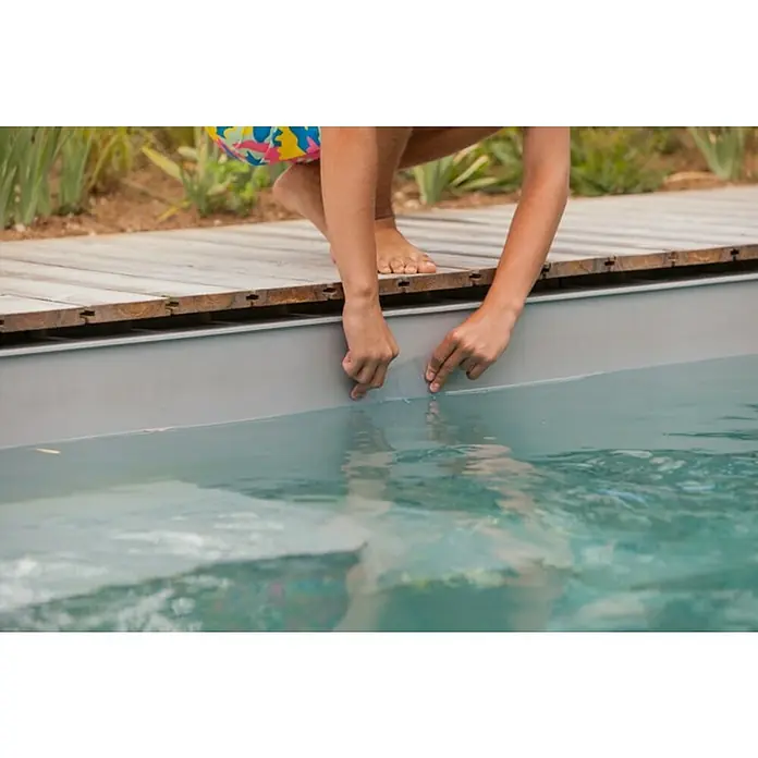 Reparaturband EasyFix - Transparent, 150 x 10 cm - Eine Person, die mit den Fingerspitzen das Wasser in einem Pool berührt, der von einer Holzterrasse umgeben ist.