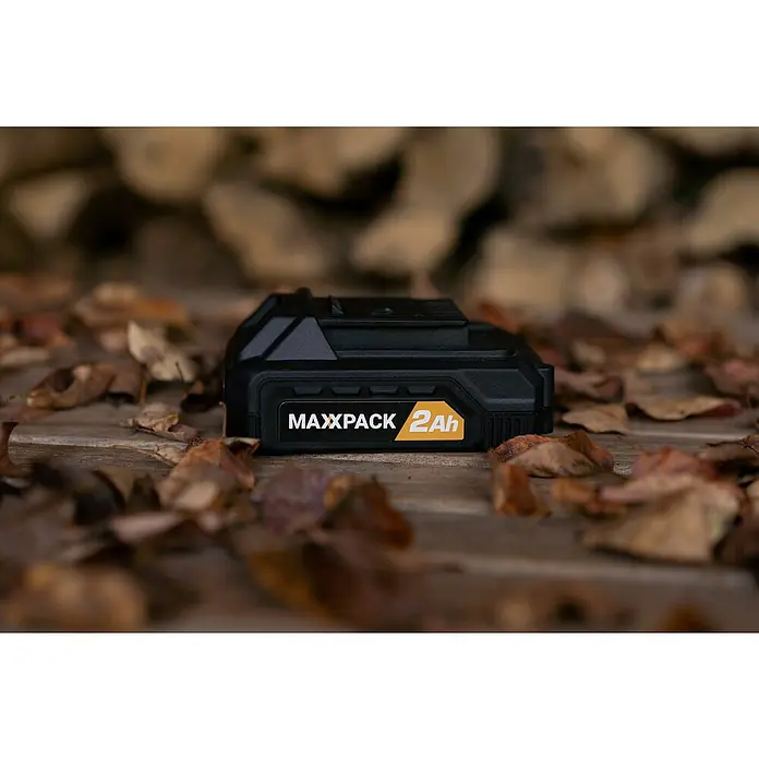 Batavia Maxxpack Akku - 18 V, 2 Ah, Li-Ionen - Nahaufnahme eines schwarzen Maxxpack 2Ah Akkus, der auf einem Holztisch mit Laub liegt.
