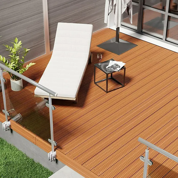 Terrassendiele Premium/Select - Bangkirai, 300 x 14,5 x 2,5 cm, Braun - Sonnenliege auf einer Terrasse mit Holzboden, neben einem kleinen Tisch mit Getränk und Zeitschriften. Entspannung pur im Freien!