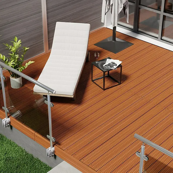 Terrassendiele Premium/Select - Bangkirai, 180 x 14,5 x 2,5 cm, Braun - Ein stilvolles Deck mit einer Sonnenliege, einem kleinen Tisch und einer Pflanze, perfekt für entspannende Momente im Freien.