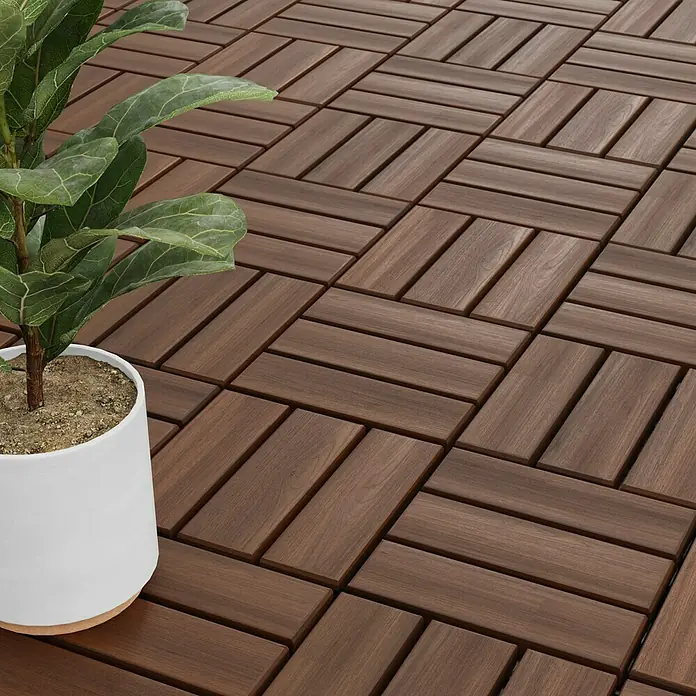 Loseta con sistema click - Madera de acacia, 30 x 30 x 2 cm, Marrón oscuro, 5 ud. - Baldosas de patio de madera oscura con una planta en maceta. Las baldosas están dispuestas en un patrón de espiga para un aspecto elegante.