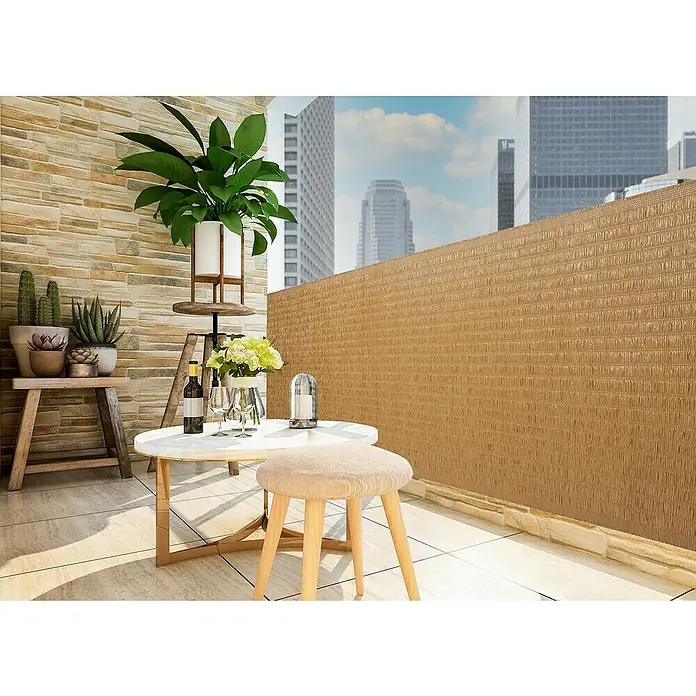 Gardol Balkonsichtschutz Raffia - Beige, 300 x 90 cm - Balkon-Szene mit einer stilvollen, weißen Tischgarnitur, grünen Pflanzen und einem blickdichten, braunen Sichtschutz für mehr Privatsphäre.