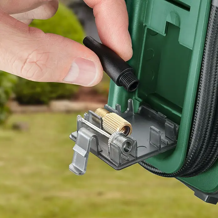 Bosch Power for All 18V Akku-Luftpumpe UniversalPump - 18 V, Ohne Akku - Nahaufnahme einer Hand, die einen schwarzen Aufsatz an ein grünes Gehäuse mit Düsen hält.