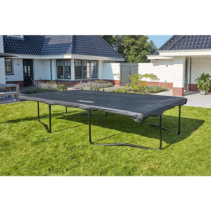Salta Trampolin-Abdeckplane - 305 x 214 cm, Schwarz - Eine schwarze Salta Trampolin Abdeckung liegt auf einem Trampolin im Garten, schützt es vor Witterungseinflüssen und hält es sauber.