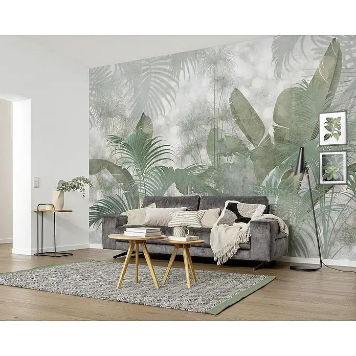 Komar Colours Fototapete Paillet. Tropicales - B x H: 368 cm x 248 mm, Vlies - Wohnzimmer mit grauem Sofa vor einer botanischen Tapete, zwei Beistelltischen und einem Teppich.