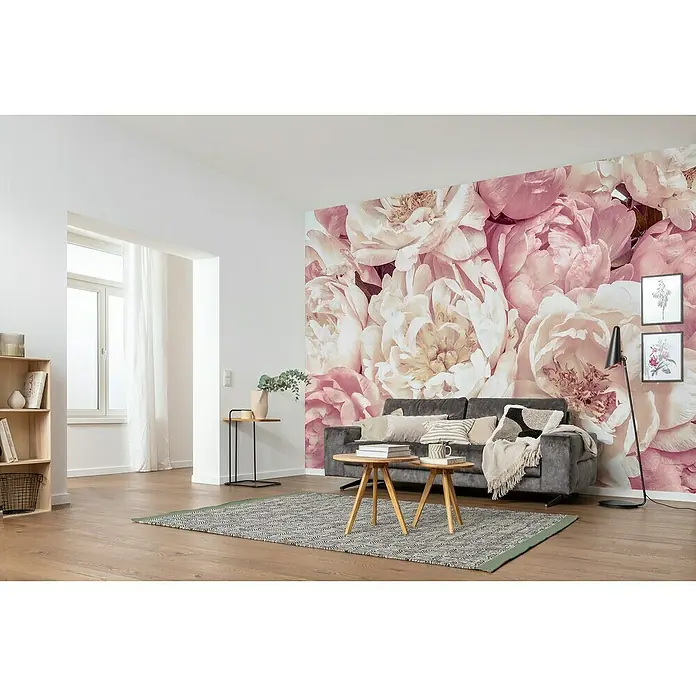 Komar Colours Fototapete Peonies - B x H: 368 cm x 248 mm, Vlies - Wohnzimmer mit einer Wand voll von rosa Pfingstrosen, einem grauen Sofa und einem gemusterten Teppich.