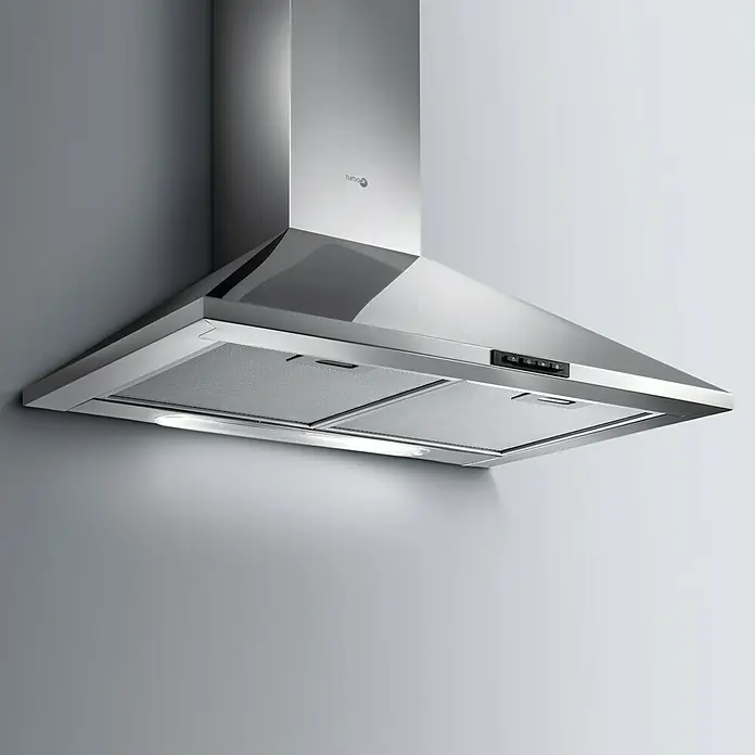 Turboair Campana de pared Certosa Plus - Ancho: 60 cm, Máx. Potencia del ventilador en modo extracción: 559 m³/h, Acero inoxidable - Primer plano de una campana extractora de acero inoxidable montada en una pared gris, que ofrece elegancia moderna para cualquier cocina.