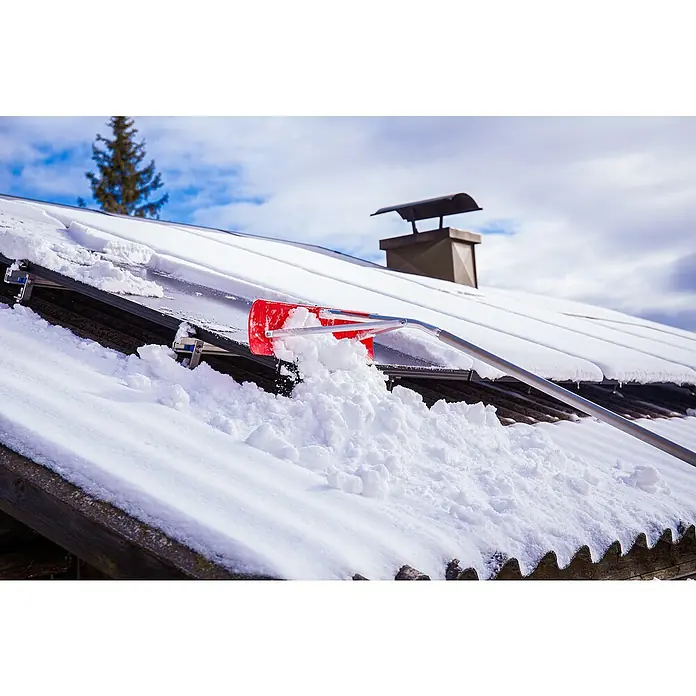 Freund Victoria Schneeschieber Dachräumer - Breite: 60 cm, Teleskopstiel - Eine rote Dachlawinenharke wird verwendet, um Schnee von einem Dach mit Solarmodulen vor einem bewölkten Himmel zu entfernen.