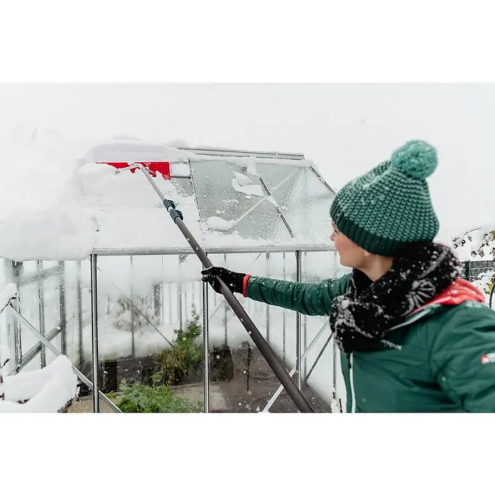Freund Victoria Schneeschieber Dachräumer - Breite: 60 cm, Teleskopstiel - Frau entfernt Schnee von einem Gewächshaus mit einem Schneeschieber, um das Sonnenlicht für Pflanzen zu maximieren.