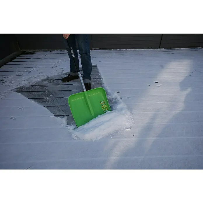 Freund Victoria Kunststoff-Schneeschaufel - Breite: 40 cm, Material Stiel: Aluminium - Eine grüne Schneeschaufel von FREUND wird verwendet, um Schnee von einer Holzterrasse zu räumen. Die Schaufel ist voll mit Schnee.