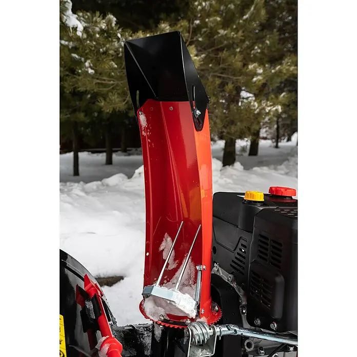 AL-KO Premium Benzin-Schneefräse SnowLine 620 E III - 6,2 kW, 302 cm³, Arbeitsbreite: 62 cm - Nahaufnahme eines rot-schwarzen Schneefräse-Auswurfsystems vor einer verschneiten Landschaft, das Design und die Funktionalität des Geräts hervorhebt.