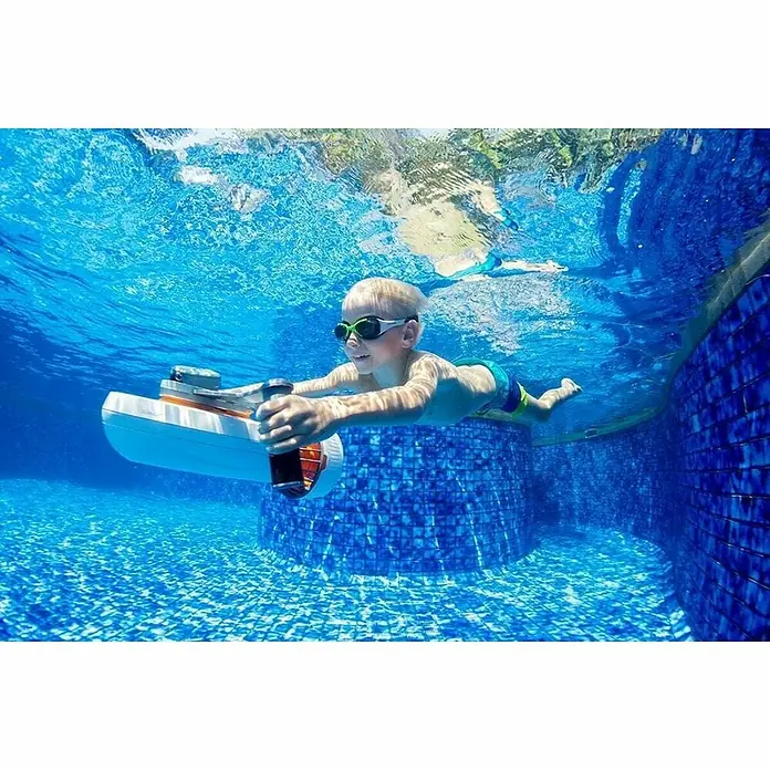 Sublue Tauchscooter Tini - L x B x H: 355 x 135 x 135 mm - Ein Junge genießt Unterwasser Spaß mit einem batteriebetriebenen Schwimmbrett im Pool, ein spannendes Wassererlebnis für Kinder.