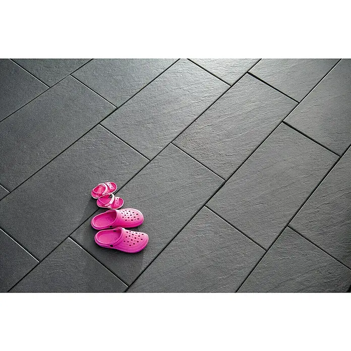 Diephaus Terrassenplatte Sonoma - 80 x 40 x 4 cm, Basalt, Beton - Zwei Paar pinke Schuhe auf einem dunklen Bodenbelag.