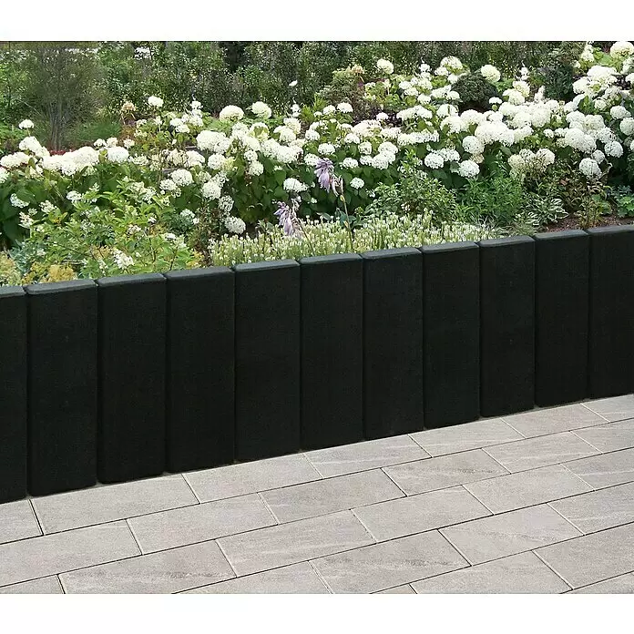 Diephaus Rechteckpalisade Mini - Anthrazit, 8 x 20 x 90 cm, Beton - Dunkelgraue Gartenbegrenzung trennt gepflasterte Terrasse von Blumenbeet mit weißen Hortensien.