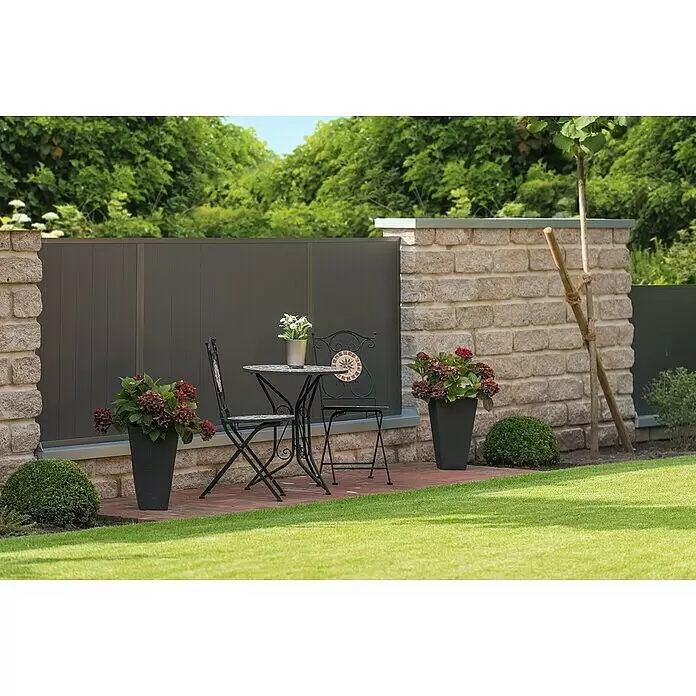 Diephaus Stamford Mauerstein Major - 50 x 25 x 15 cm, Muschelkalk, Beton, Anfangsstein - Schwarzer Bistrotisch und zwei Stühle aus Schmiedeeisen mit Mosaikakzenten auf einer Gartenterrasse.
