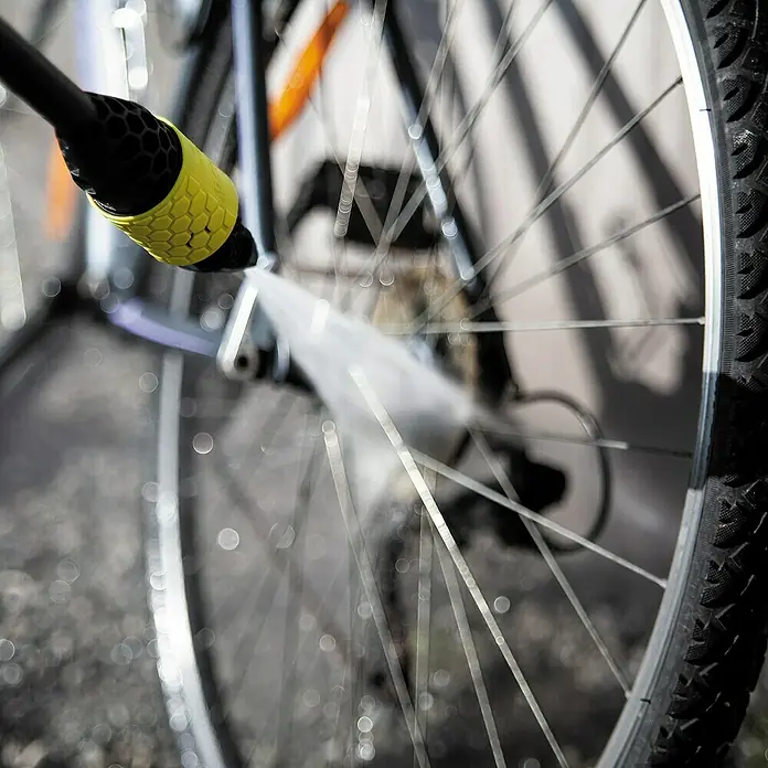 Ava Flachstrahldüse - Winkel: 25 °, Passend für: Ava Hochdruckreiniger P30-60 - Ein Fahrradreifen wird mit einem gelb-schwarzen Hochdruckreiniger gesäubert, um Schmutz zu entfernen.