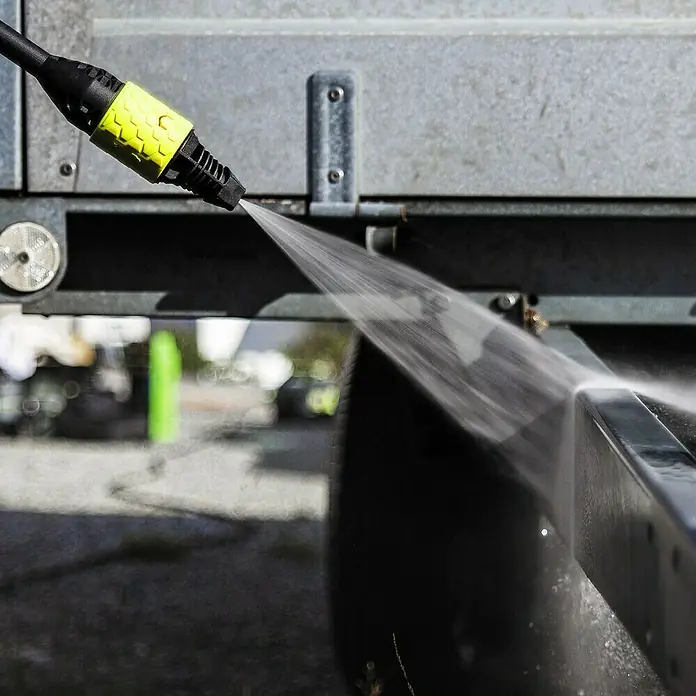 Ava Flachstrahldüse - Winkel: 25 °, Passend für: Ava Hochdruckreiniger P30-60 - Ein Hochdruckreiniger wird benutzt, um ein Fahrzeug zu reinigen. Der gelbe Aufsatz ist deutlich sichtbar, während der Wasserstrahl Schmutz entfernt.