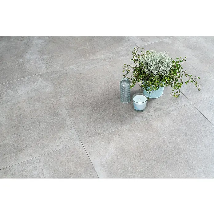Diephaus Terrassenfliese Columbia - 60 x 60 x 4 cm, Concreto Quarzit, Beton - Graue Bodenfliesen mit Pflanze, Kerze und Vase. Die Fliesen präsentieren ein elegantes, modernes Design für jeden Raum.