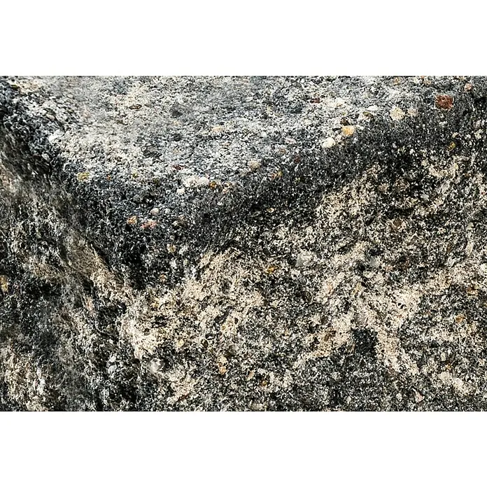 Diephaus Stamford Mauerstein Major - 50 x 25 x 15 cm, Schwarz/Weiß, Beton, Anfangsstein - Nahaufnahme eines rauen, dunkelgrauen Steins mit helleren, gesprenkelten Elementen, die seine einzigartige Textur und Zusammensetzung hervorheben.