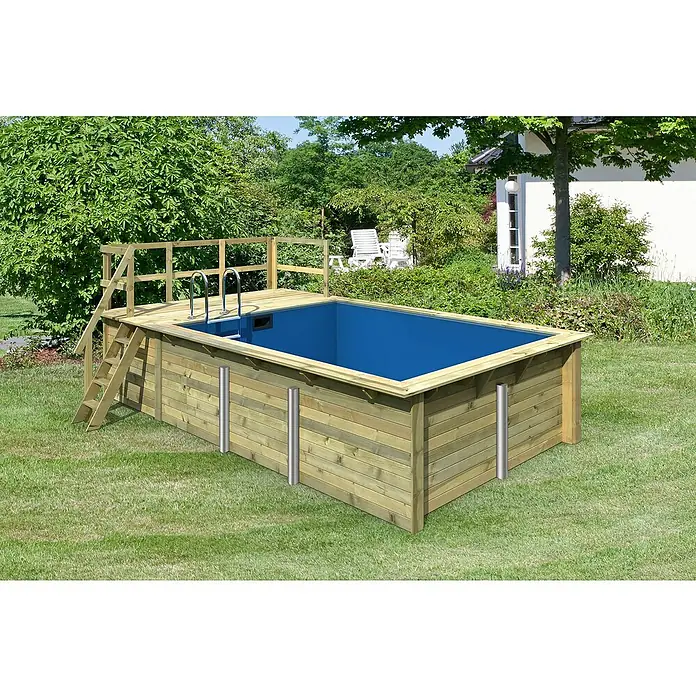 Karibu Holz-Pool Palm Beach mit Sonnenterrasse - L x B x H: 582 x 353 x 124 cm, Naturbraun, 12.700 l - Ein rechteckiger Holzpool mit Leiter und Geländer steht im Garten. Im Hintergrund sind Gartenmöbel und ein Haus zu sehen.