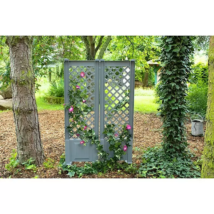 KHW Rankgitter 2er-Set - L x H: 43 x 137 cm, Grau - Graues Gartenrankgitter mit Rautenmuster, umrankt von rosa Blüten und grünen Ranken, als Sichtschutz zwischen Bäumen.