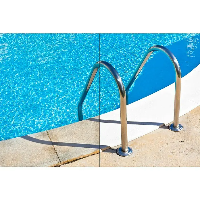 Montó Bricolovers Pintura para piscinas Renovador de bordes - Blanco hueso, 4 l, Mate sedoso - Primer plano de una escalera de piscina de acero inoxidable con vista al agua azul y borde blanco. Refrescante invitación en verano.
