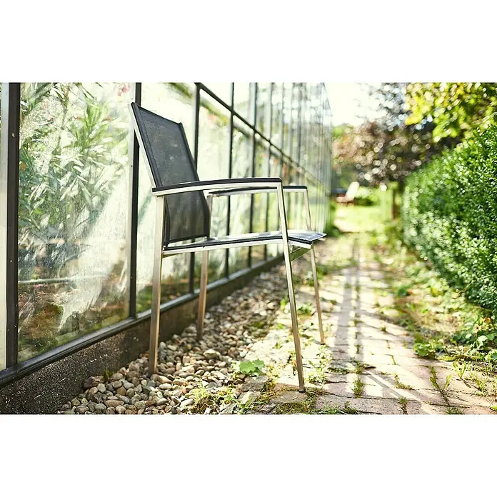 Acamp Gartenmöbel-Set Auris - 5 -tlg., Edelstahl, Polywood, Keramik, Stapelbar, Silber/Schwarz - Moderner Gartenstuhl aus Metall mit schwarzer Sitzfläche vor einem Gewächshaus. Ideal für entspannte Stunden im Freien.