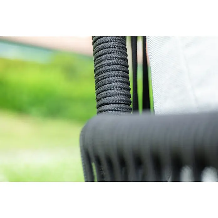 Acamp Loungemöbel-Set Mykonos - 4 -tlg., Akazie, Polyester, Grau - Detailaufnahme eines schwarzen, umwickelten Seils, das zu einem Möbelstück gehört, mit verschwommenem, grünem Hintergrund.