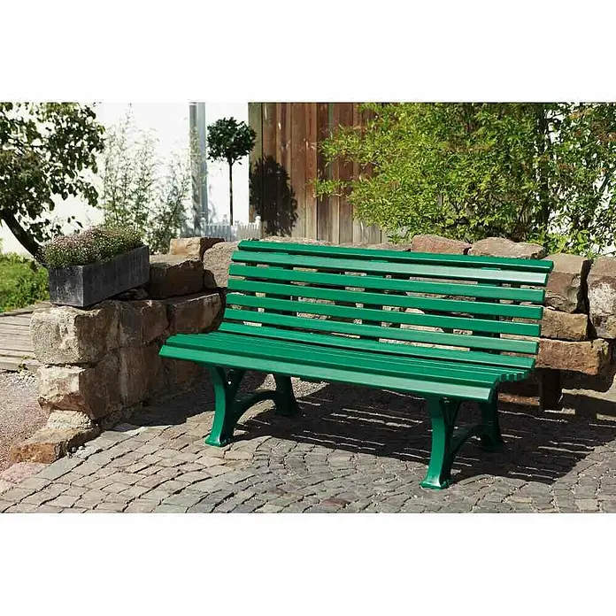 Blome Gartenbank Helgoland - B x T x H: 150 x 64 x 80 cm, Grün - Grüne Parkbank aus Holz und Metall auf einem gepflasterten Platz, eingebettet in eine Gartenlandschaft.