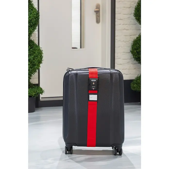 Abus Zurrgurt 620 TSA - Länge: 192 cm, Anzahl Zahlenrollen: 3 Stk., Rot - Schwarzer Koffer mit rotem ABUS Gepäckgurt und Zahlenschloss. Sicher und stilvoll reisen mit ABUS.