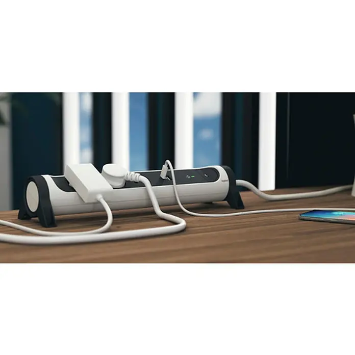 Legrand Base de enchufe múltiple con USB - x 5, Blanco/Negro, Longitud del cable: 1,5 m, IP20, Con interruptor - Regleta horizontal con cables enchufados colocada sobre una mesa.