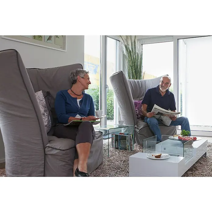 Abus Fenster-Stangenschloss FOS 550 - DIN Anschlag: Universell einsetzbar, Weiß - In einer hellen, freundlichen Atmosphäre sitzen zwei Personen entspannt in grauen Sesseln. Der Couchtisch und die Dekoration ergänzen das moderne Ambiente.