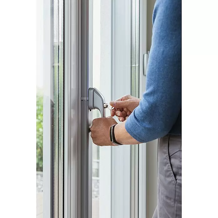 Abus Fenster-Stangenschloss FOS 550 - DIN Anschlag: Universell einsetzbar, Weiß - Person verriegelt silbernen Fenster-/Türgriff mit Schlüssel.