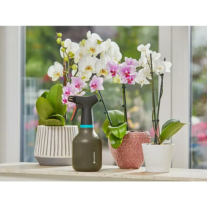 Gardena Handsprüher - Schwarz, 0,75 l - Nahaufnahme einer Gardena-Sprühflasche mit Pflanzen im Hintergrund, ideal für die Zimmerpflanzenpflege.