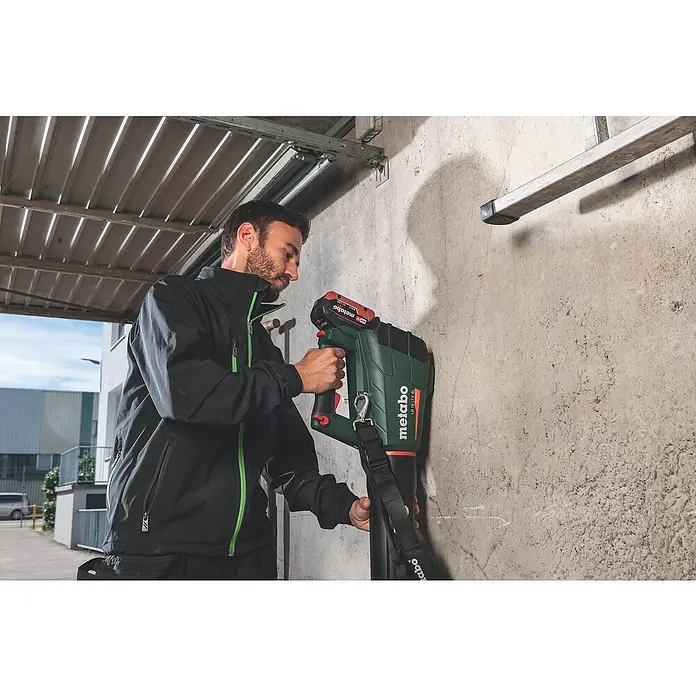 Metabo CAS 18V Akku-Laubbläser LB 18 LTX BL - 18 V, Li-Ionen, 2 Akkus, Blasgeschwindigkeit: 150 km/h - Ein Mann bedient eine Metabo Akku-Leuchte LP 18 LTX BL auf einer Baustelle, wobei die robuste Bauweise und das helle Licht hervorgehoben werden.