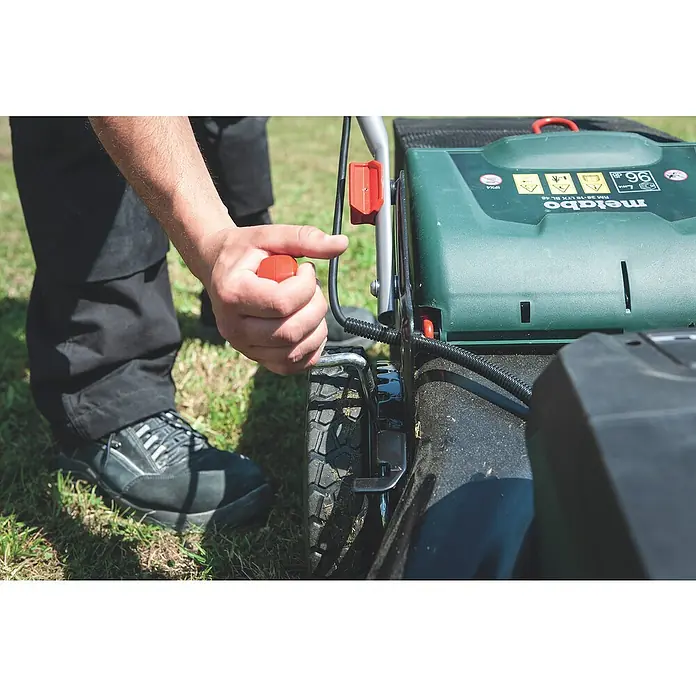 Metabo CAS 18V Akku-Rasenmäher RM 36-18 LTX BL 46 - 18 V, Ohne Akku, 5,2 Ah, Schnittbreite: 46 cm - Eine Person bedient einen Metabo Rasenmäher mit rotem Griff, der auf einer grünen Rasenfläche steht.