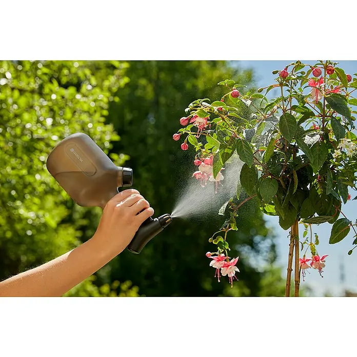 Gardena Handsprüher - 1 l - Eine Person bewässert eine blühende Pflanze mit einem Gardena-Sprühgerät. Das Sprühgerät ist ergonomisch geformt und einfach zu bedienen.