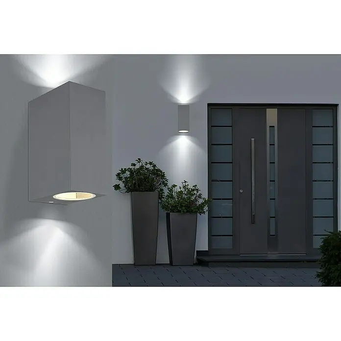 Globo Aplique exterior Veronika - 35 W, 9,2 x 6,8 x 15 cm, Antracita, IP44 - Vista exterior moderna con puerta de entrada gris y elegantes luces de pared que crean un ambiente acogedor. Las jardineras complementan el diseño.