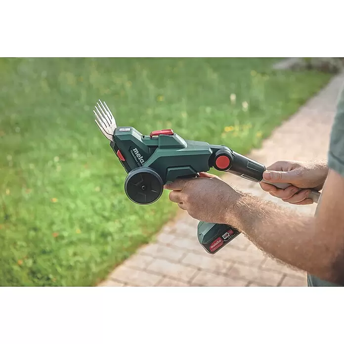 Metabo Akku-Gras- & Strauchschere PowerMaxx SGS 12 Q - 12 V, Li-Ionen, Ohne Akku, Schwertbreite: 13 cm - Eine Person hält eine dunkelgrüne Metabo Akku-Grasschere mit angesetztem Akku, einsatzbereit.